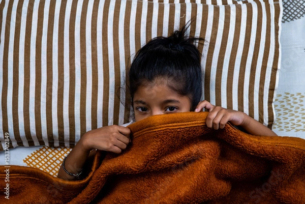 Obraz Child hiding under blanket in cozy bedroom setting