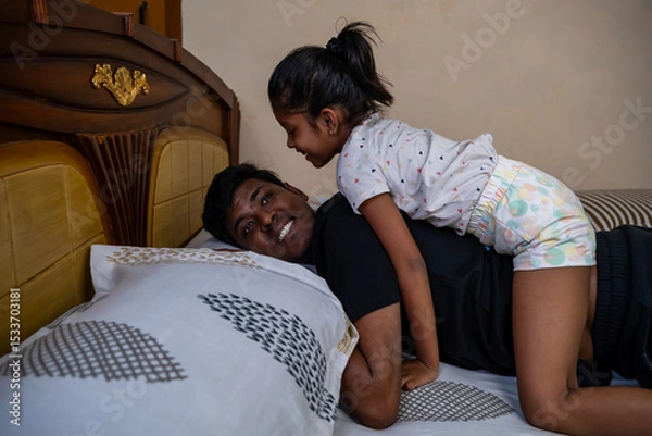 Obraz Dad and daughter sharing laughter on the bed together