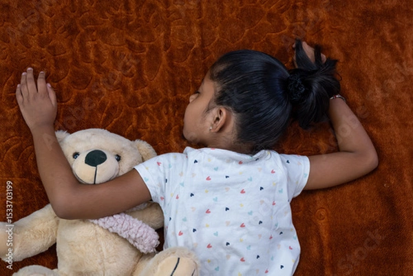 Obraz Child sleeping peacefully with teddy bear on cozy blanket