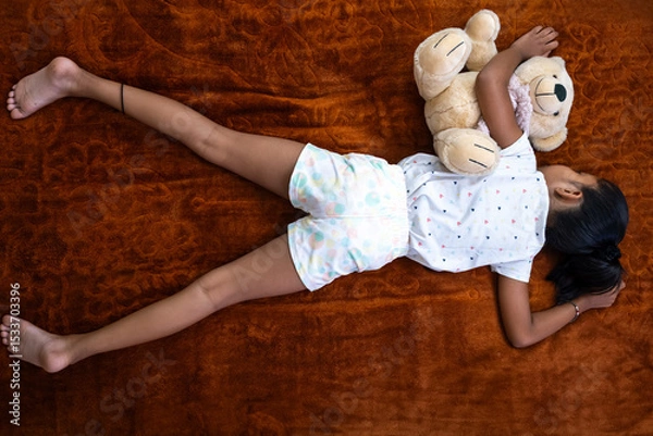 Obraz Child sleeping peacefully with teddy bear on the floor
