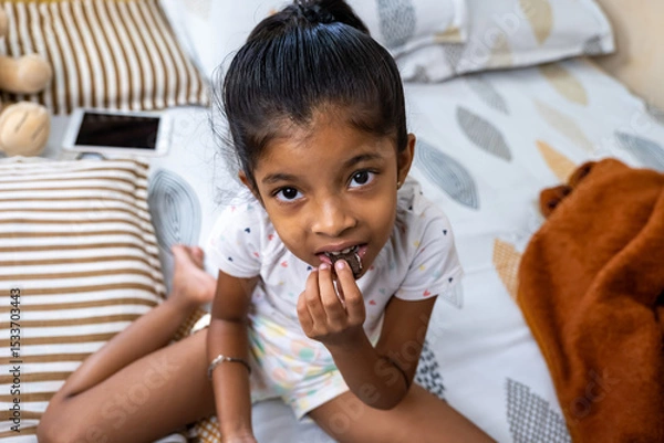 Obraz Girl enjoying a chocolate snack at home during the afternoon