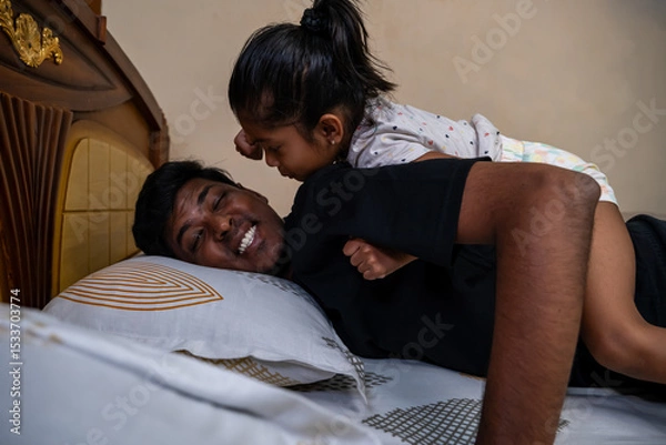 Obraz Smiling father enjoys playful moment with daughter at home
