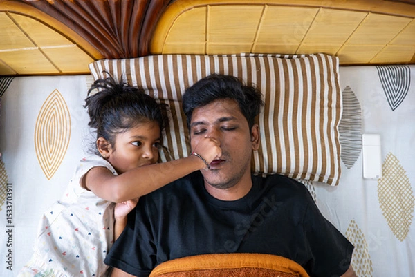 Obraz Kid playfully interacting with a sleeping father at home