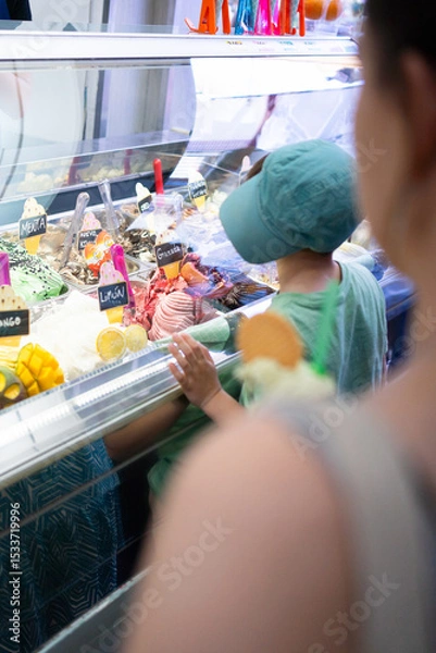 Fototapeta Child choosing ice cream flavor from display case in gelateria