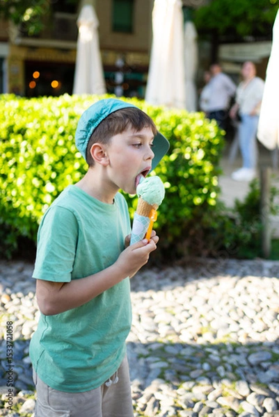 Fototapeta Boy enjoying refreshing mint ice cream on a sunny day