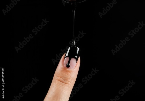 Obraz Black liquid dripping onto a finger with a black background in a studio setting close up shot