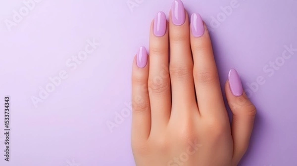 Fototapeta Close-up of a woman's hand showcasing a pastel purple manicure.  Soft, elegant nails against a matching background.