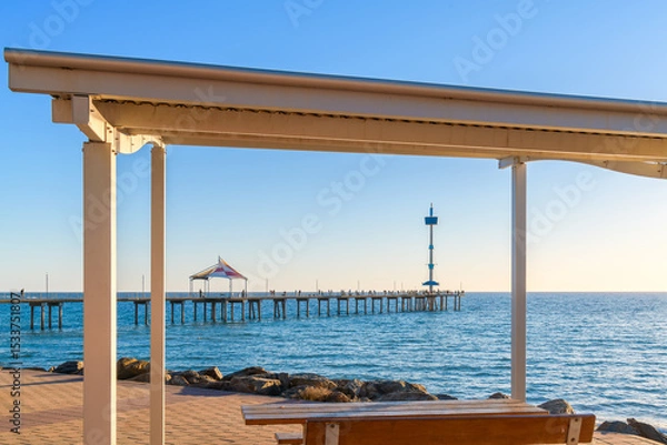 Fototapeta Brighton Jetty with people viewed from Esplanade through picnic gazebo on a bright day, Adelaide, South Australia