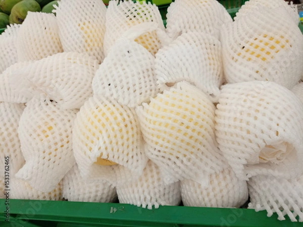 Obraz Pears wrapped in foam net are neatly arranged on supermarket shelves for sale