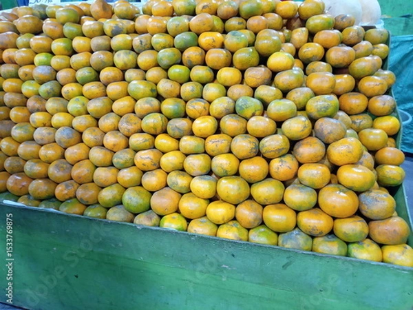 Obraz Oranges neatly arranged on a wooden shelf in a grocery store.