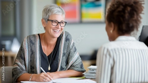 Fototapeta Bright-eyed HR specialist engages in a confidential mental health consultation, listening attentively to a client's concerns in a modern office filled with natural light