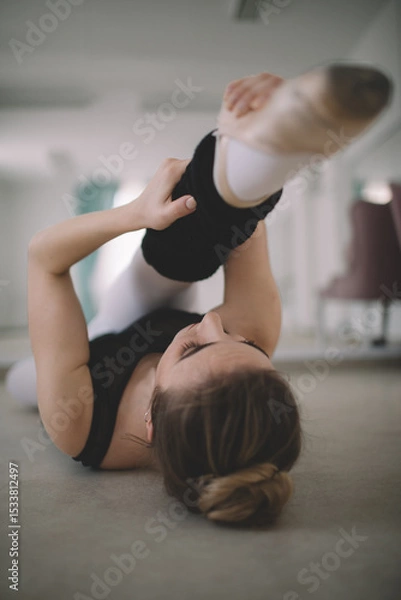 Fototapeta Ballet dancer stretching on the floor