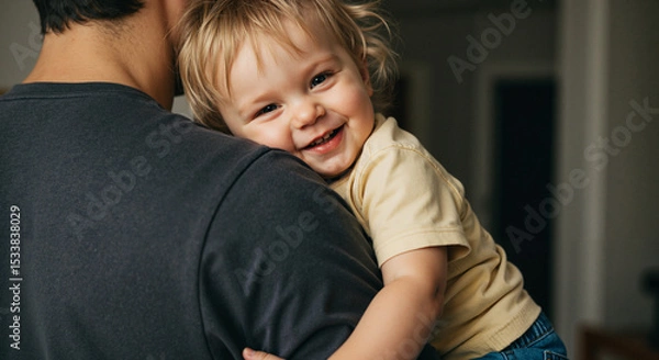 Obraz Toddler smiling while being held on parent's shoulder at home  