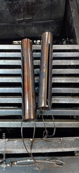 Fototapeta Round blanks with a longitudinal hole are placed on the grate above the oil tank after quenching