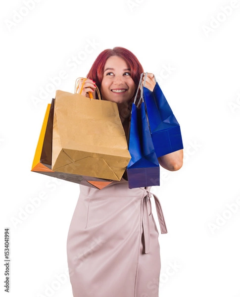 Fototapeta Positive thinking redhead woman holding shopping bags to cheeks, looking away dreaming and imagining isolated on transparent background with copy space