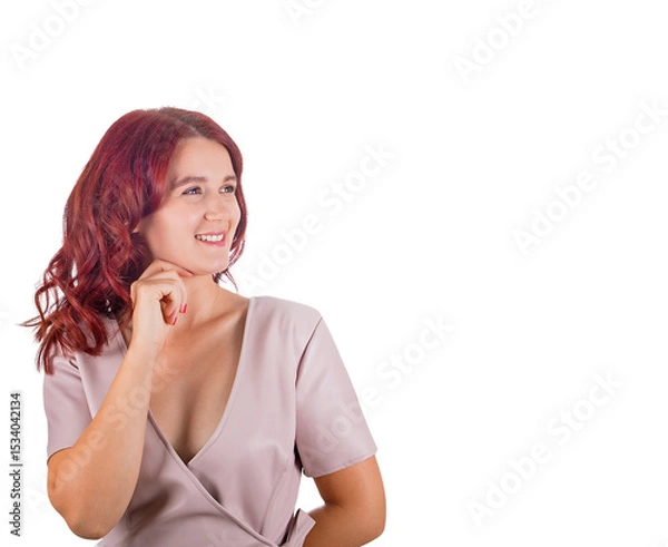 Fototapeta Pensive redhead woman keeps hand under chin thoughtful looking aside, finding solutions to her questions