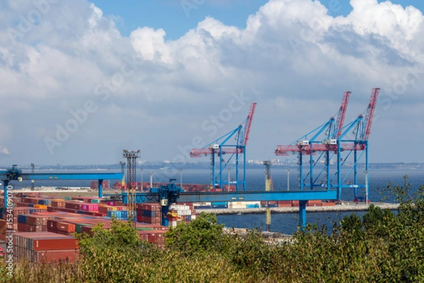 Fototapeta A wide shot shows the busy Port of Odesa Ukraine featuring towering gantry cranes moving numerous brightly colored shipping containers, illustrating maritime industry and international commerce.