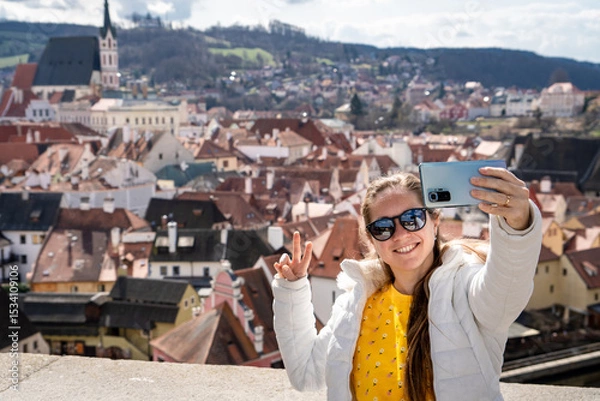 Obraz Mujer turista compartiendo las vistas de český krumlov con una selfie