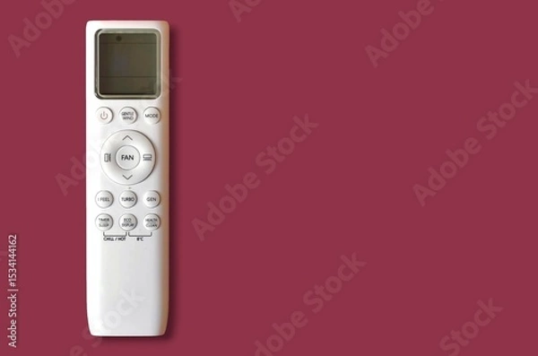 Fototapeta Top view of a white air conditioner remote control with LCD screen, isolated on a maroon background with space for text.