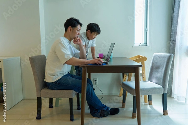 Fototapeta 自宅の部屋でパソコンを操作する父親と男の子