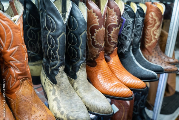 Fototapeta Handcrafted Mexican cowboy boots in various exotic leathers and colors displayed in a traditional Guadalajara market stall