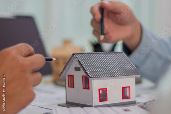 Fototapeta Architect and businessman discussing interior mansion plans using pencils and models at desk, including real estate purchase planning with leaders, marketing and engineering insights.