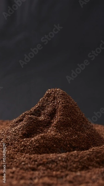 Fototapeta Aromatic Ground Coffee Beans forming a unique peak texture against a dark background