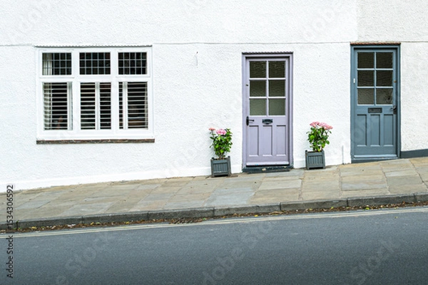 Fototapeta Abstract view of a pair of terraced houses seen up a hilly road in England. The road and pavement is partially hazardous in poor weather.