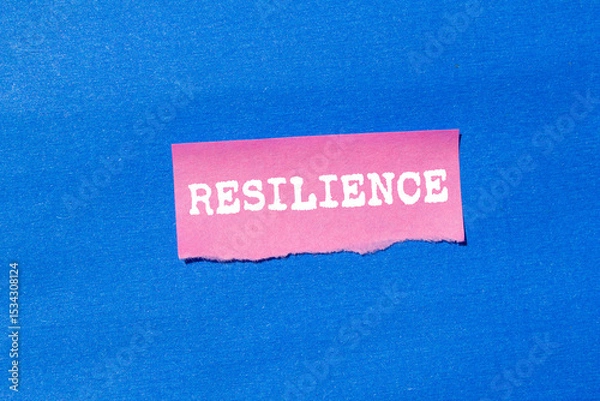 Obraz Resilience message written on ripped torn pink paper on blue background. Conceptual resilience symbol. Copy space.