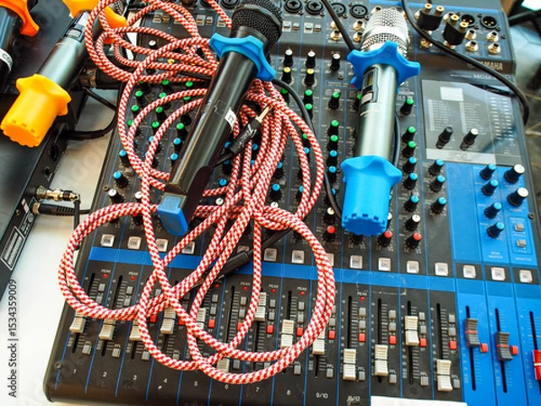 Fototapeta audio mixer console, along with messy microphones and cables on top of it.