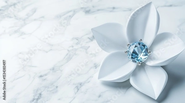 Fototapeta Elegant white flower-shaped jewelry with a light blue gemstone on a marble surface.