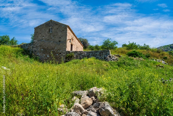Obraz Old stone chapel on green Akrokorinthos hillside