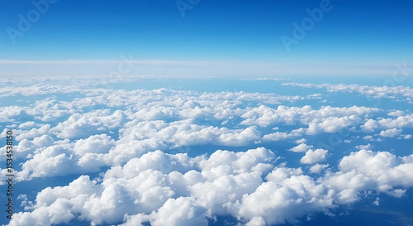 Fototapeta Beautiful aerial view of a serene blue sky filled with fluffy white clouds during daytime.