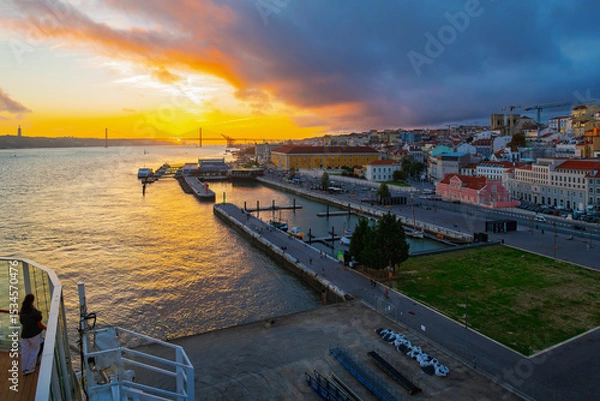 Fototapeta Sunset view from the upper deck of a cruise ship at port of the city of Lisbon Portugal, Tagus River and the Ponte 25 de Abril bridge.