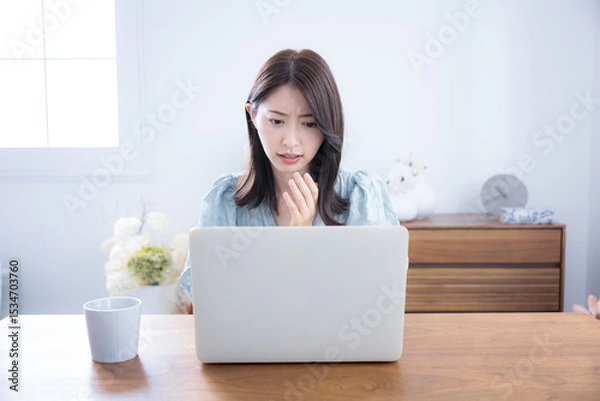 Fototapeta Cute woman lost in her room thinking and worrying about her computer A little serious negative image Surprised and surprised expression