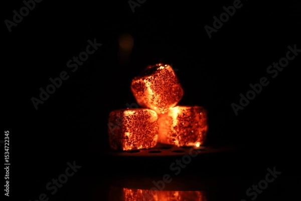 Fototapeta Glowing coals with glitch style lighting, enriched by noise, effect and grain details, create a mystical atmosphere in the dark. A vivid sense of heat and depth surrounds the image