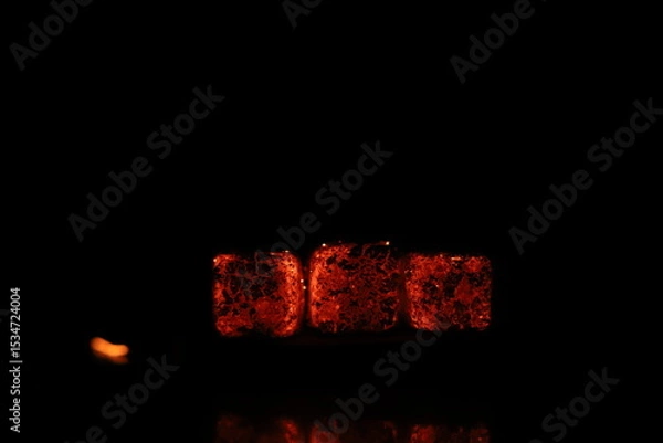 Fototapeta Glowing coals with glitch style lighting, enriched by noise, effect and grain details, create a mystical atmosphere in the dark. A vivid sense of heat and depth surrounds the image