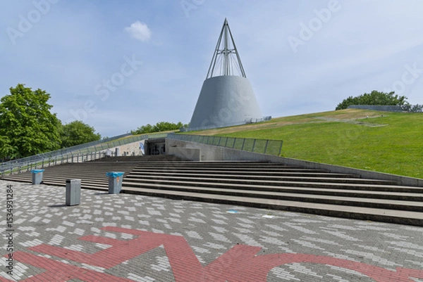 Obraz The iconic TU Delft Library building, featuring a distinctive conical roof and a sloping green roof, a landmark of modern architecture.