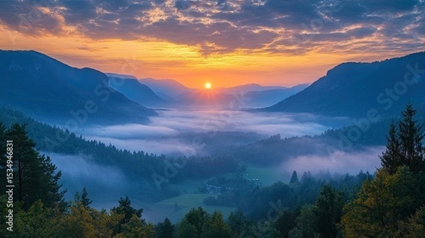 Obraz Dichter Morgennebel liegt Ã?Â¼ber majestÃ?Â¤tischen Bergen, wÃ?Â¤hrend die Sonne langsam aufgeht und Licht ins Tal bringt  