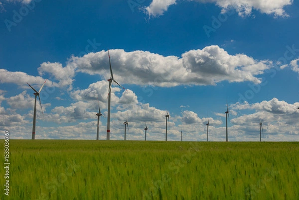 Obraz Modern wind turbines spinning over vibrant green fields in rural Germany. A powerful symbol of the Energiewende and Germany’s response to climate change and energy transition. green energy