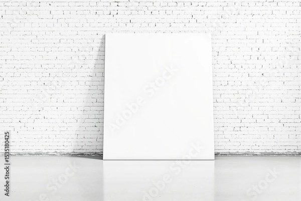 Fototapeta Blank white canvas leaning against a white brick wall in a minimalist space.