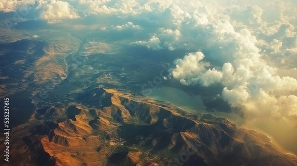 Obraz Aerial view of rugged mountain terrain with rolling hills, lush valleys, and dramatic cloud formations, showcasing the beauty of nature and landscape photography