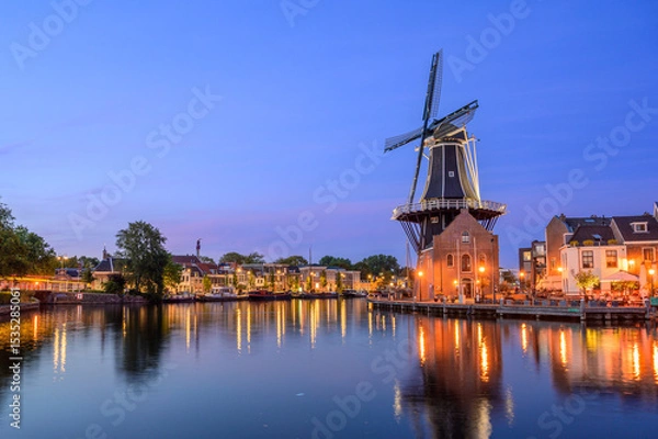 Fototapeta Windmill de adriaan and cityscape reflections on spaarne river in haarlem, netherlands