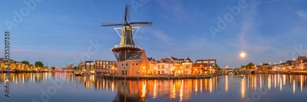 Fototapeta Windmill de adriaan and cityscape reflections on spaarne river in haarlem, netherlands