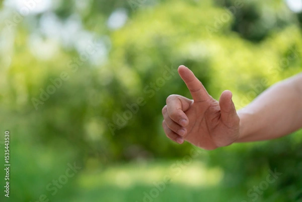 Obraz A hand reaching out against a soft green background, symbolizing connection, guidance, or the act of giving/receiving. Ideal for concepts of nature, help, or interaction.