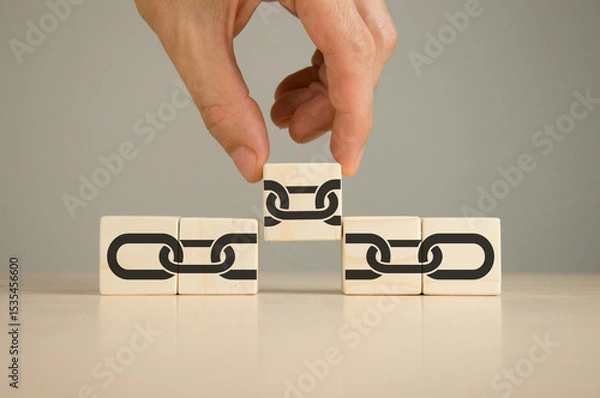 Obraz Businessman puts wooden cubes with chain links
