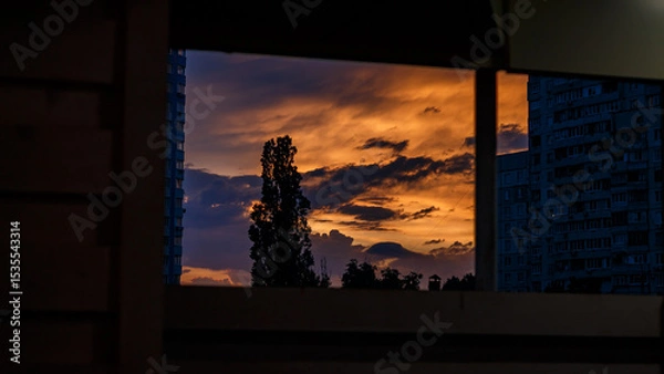 Obraz Sunset in Kharkiv. Cityscape. Orange Sky. View from Window. Tree Silhouette. Evening Clouds. Ukrainian City. Kharkiv Buildings. Atmospheric Sky.