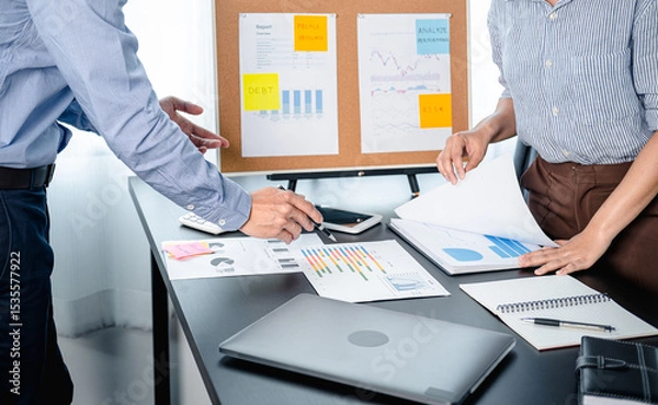 Obraz Two business colleagues pointing on document chart to brainstorming about new startup project and putting post it notes