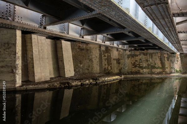 Fototapeta Underside of the railway bridge where the Great Western Main Line crosses the Grand Union Canal in Hayes, West London, UK.
