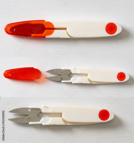 Fototapeta White plastic thread cutting scissors in a red case on a white background.  Sewing clippers tailor scissors tool. 